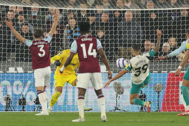 Newcastle United's Brazilian midfielder #39 Bruno Guimaraes (R) scores the opening goal of the English Premier League football match between West Ham United and Newcastle United at the London Stadium, in London on March 10, 2025. (Photo by Adrian Dennis/AFP Photo)