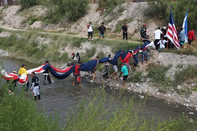 Venezuelan migrants cross the Rio Bravo river (or Rio Grande river, as it is called in the US) to hold a demonstration against the US immigration policies in Ciudad Juarez, Mexico, on October 31, 2022. (Photo by Herika Martinez/AFP Photo)