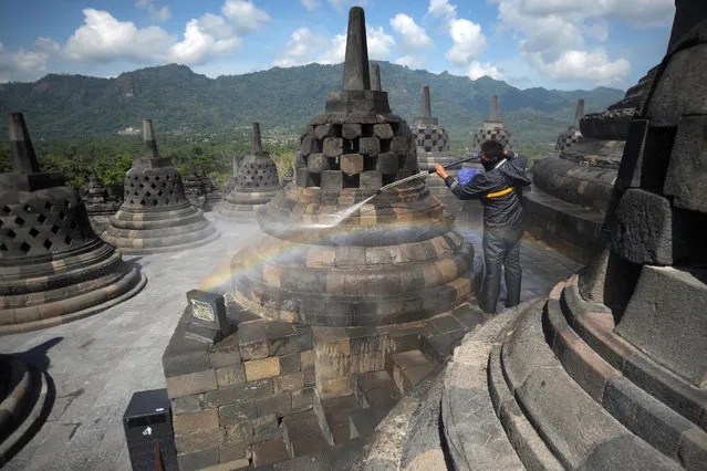 A worker cleans volcanic ash off the stupas at the Borobudur temple in Magelang Regency on June 22, 2020, a day after Mount Merapi erupted in nearby Sleman, sending a plume of ash into the sky. Indonesia's Mount Merapi, one of the world's most active volcanoes, erupted twice on June 21, sending clouds of grey ash 6,000 metres into the sky, the country's geological agency said. (Photo by Agung Supriyanto/AFP Photo)