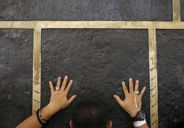 A Muslim pilgrim touches the holy Kaaba at the Grand Mosque on the first day of Eid al-Adha during the annual haj pilgrimage in Mecca September 24, 2015. (Photo by Ahmad Masood/Reuters)