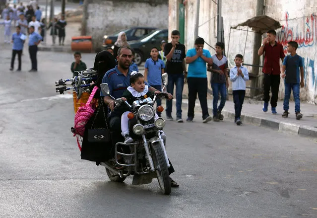 A Palestinian girl rides a motorcycle with her father as she makes her way to her school, on the first day of a new school year, in Khan Young in the southern Gaza Strip August 28, 2016. (Photo by Ibraheem Abu Mustafa/Reuters)