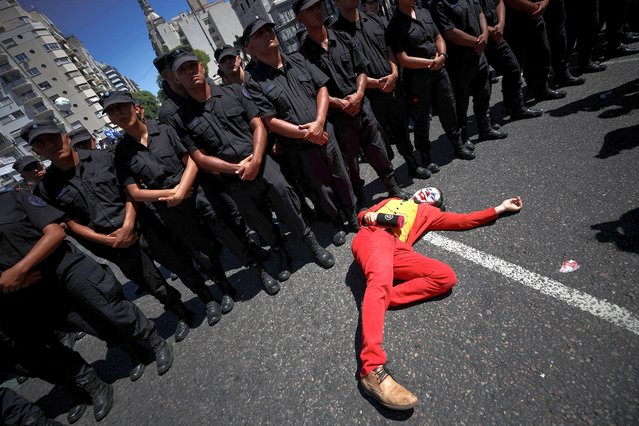 A journalist, dressed as the “Joker”, lies on the ground in front of police members during a one-day national strike, outside the National Congress, in Buenos Aires, Argentina, on January 24, 2024. (Photo by Agustin Marcarian/Reuters)