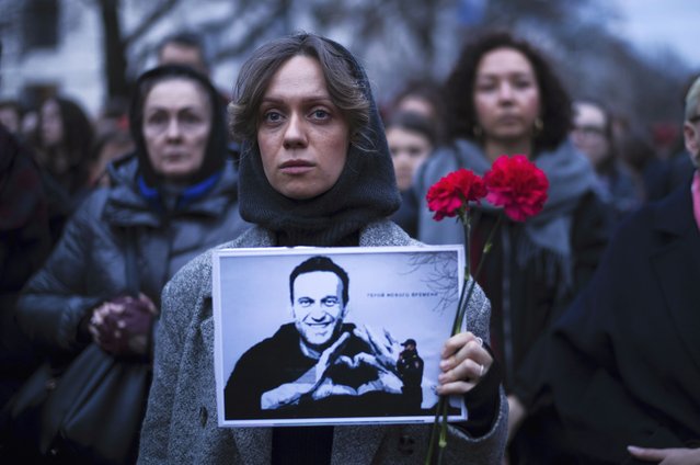A woman holds flowers and a portrait of opposition leader Alexei Navalny during a protest in front of the Russian embassy in Berlin, Germany, Friday, February 16, 2024. Russia's prison agency says that imprisoned opposition leader Alexei Navalny has died. He was 47. The Federal Prison Service said in a statement that Navalny felt unwell after a walk on Friday Feb. 16, 2024 and lost consciousness. (Photo by Markus Schreiber/AP Photo)