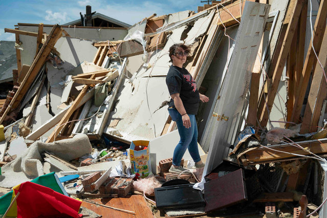 A woman inspects damage from a tornado in London, Kentucky, on May 17, 2025. More than 20 people have died after severe storms swept through the southern US states of Missouri and Kentucky, officials and local media reports said May 17, 2025. Kentucky governor Andy Beshear said on X that at least 14 people had died in Friday night's storms. At least seven people were killed in Missouri, the Washington Post reported. (Photo by Allison Joyce/AFP Photo)