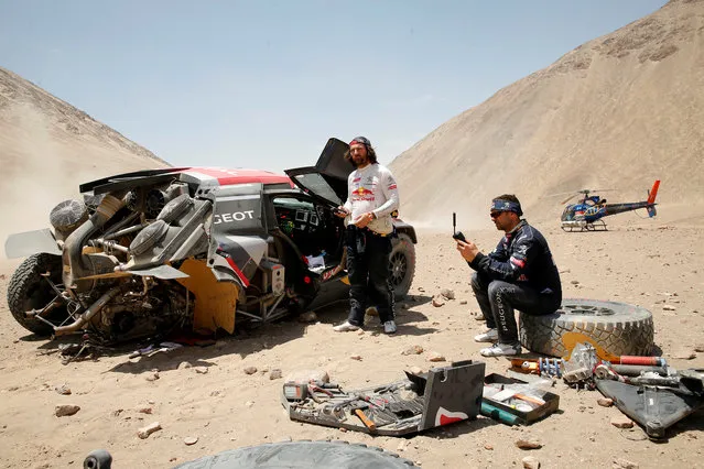 Peugeot' s French driver Cyril Despres (L) and co- driver David Castera react after a crash during Stage 4 of the Dakar 2018 in and around San Juan De Marcona, Peru, on January 9, 2018. (Photo by Andres Stapff/Reuters)