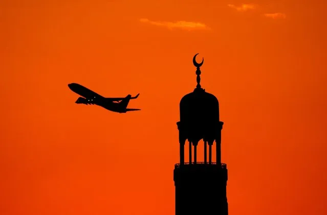 A plane leaves Qatar Airport as the sun rises behind the Mosque at Souq Waqif in Doha, Qatar on Friday, December 9, 2022. (Photo by Peter Byrne/PA Images via Getty Images)