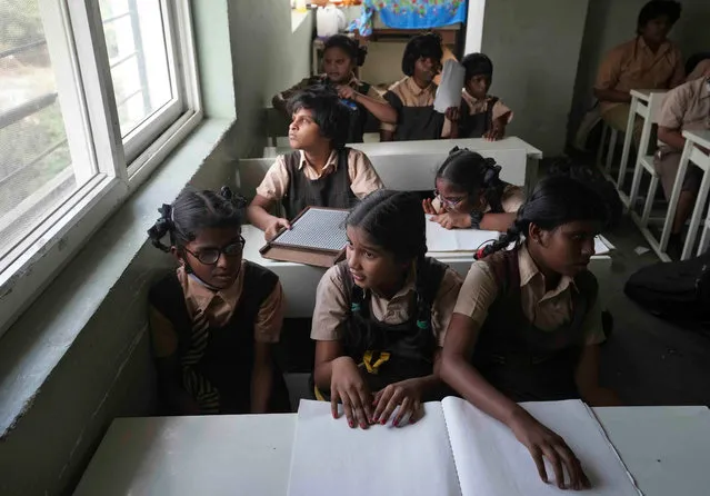 Students with visual disabilities read a book in braille at the Devnar School for the Blind in Hyderabad, India, Tuesday, January 3, 2023. World Braille Day will be observed on Jan. 4, marking the birth anniversary of Louis Braille, the French inventor who devised a system used by the blind for reading and writing. (Photo by Mahesh Kumar A./AP Photo)