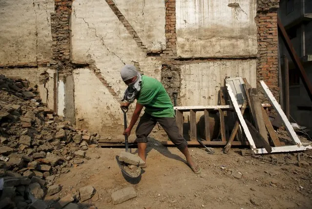 A man works to rebuild a house a year after the 2015 earthquakes in Bhaktapur, Nepal, April 25, 2016. (Photo by Navesh Chitrakar/Reuters)