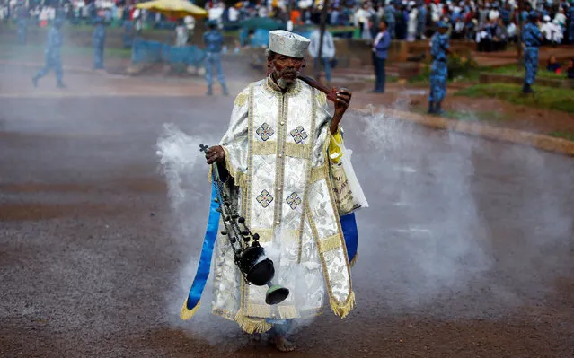 An Ethiopian Orthodox priest blesses the faithful with incense during the Meskel Festival to commemorate the discovery of the true cross on which Jesus Christ was crucified on, at the Meskel Square in Ethiopia's capital Addis Ababa, September 26, 2016. (Photo by Tiksa Negeri/Reuters)