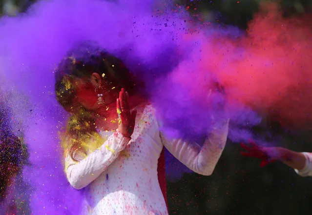 Indian college girls throw coloured powder to one another during Holi festival celebrations in Bhopal on February 28, 2018. Holi, the popular Hindu spring festival of colours, is observed in India at the end of the winter season on the last full moon of the lunar month, and will be celebrated on March 1 this year. (Photo by AFP Photo/Stringer)