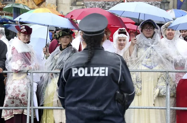 Police watches spectators in costumes during celebrations marking the German Unification Day in Dresden, Germany, October 3, 2016. (Photo by Fabrizio Bensch/Reuters)