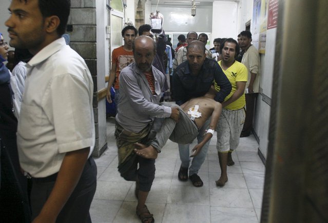 People carry a man at a hospital after he was injured by a shelling during clashes between Houthi militants and pro-government militants in Yemen's southwestern city of Taiz October 26, 2015. (Photo by Reuters/Stringer)
