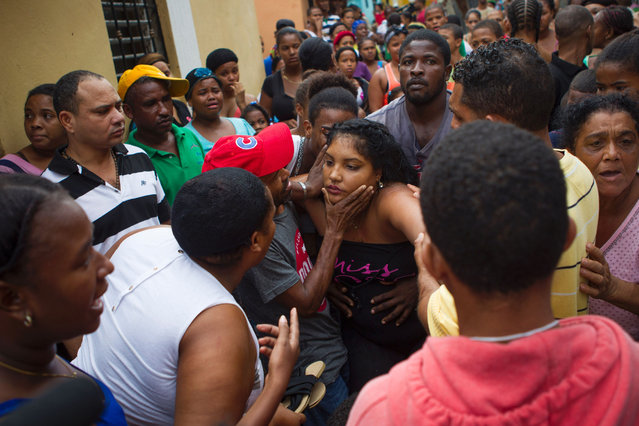 The mother of two deceased children is comforted outside her house in the neighbourhood of Capotillo, in Santo Domingo on October 4, 2016 after the passage of Hurricane Matthew through Hispaniola – the island that the Dominican Republic shares with Haiti. Matthew, a Category Four hurricane, slammed into the Dominican Republic and Haiti Tuesday, triggering major floods and forcing thousands to flee the path of the storm that has claimed at least three lives in each country. (Photo by Erika Santelices/AFP Photo)