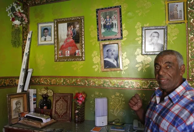 63-year-old fisherman El Hag Saleh shows family pictures inside his house in the fishermen's village in the El Max area of the Mediterranean city of Alexandria September 12, 2014. (Photo by Amr Abdallah Dalsh/Reuters)