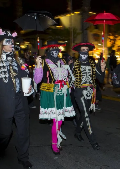 Participants march during a candlelight procession at the end of a three-day "Day of The Dead" (Dia de los Muertos) celebration, which saw hundreds walk to El Campo Santo cemetery in Old Town San Diego, California, November 2, 2015. (Photo by Mike Blake/Reuters)