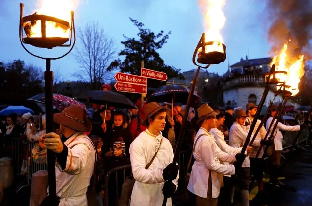 Torch carriers of the Compagnie 1602 take part in a procession in Geneva on December 14, 2014. (Photo by Pierre Albouy/Reuters)