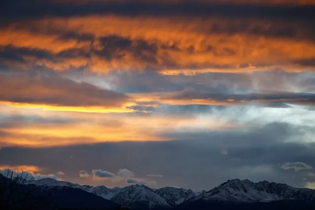 The summits of snow covered mountains are silhoutted during sunset in the western Austrian city of Innsbruck November 28, 2014. (Photo by Dominic Ebenbichler/Reuters)