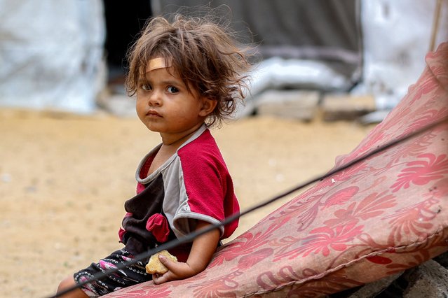 A girl sits outside one of the tents sheltering people displaced by war at the Qatari-built and now-damaged Hamad City residential complex in northwestern Khan Yunis, in the southern Gaza Strip, on October 6, 2025. Delegations from Hamas, Israel and the United States are holding talks in Egypt on October 6, with President Donald Trump urging negotiators to “move fast” to end the nearly two-year war in Gaza. (Photo by Omar Al-Qattaa/AFP Photo)