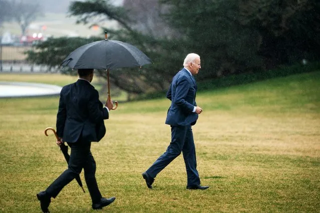 US President Joe Biden jogs to the Oval Office in the rain after arriving via Marine One on the South Lawn of the White House on Thursday, February 16, 2023. The President returned after a physical exam at Walter Reed National Military Medical Center. (Photo by Demetrius Freeman/The Washington Post)
