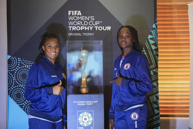 Haitian goalkeeper Kerly Theus, left, and fellow teammate Esthericove Joseph, pose for a photo alongside the Women’s World Cup trophy during a ceremony as part of its global tour, in Port-au-Prince, Haiti, Saturday, April 15, 2023. A FIFA delegation is traveling with the trophy to all 32 nations participating in the soccer tournament, which kicks off on July 20th, co-hosted by Australia and New Zealand. (Photo by Joseph Odelyn/AP Photo)