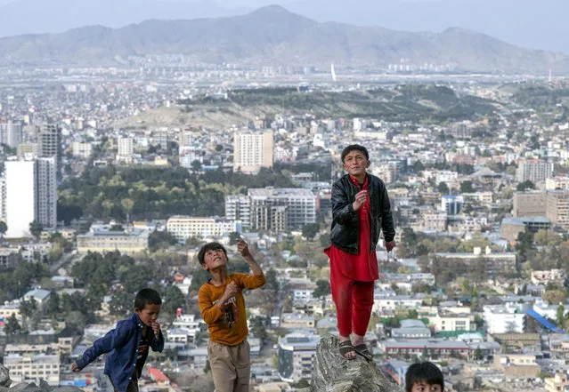 Afghan boys fly a kite at a hilltop in Kabul on April 10, 2023. (Photo by Wakil Kohsar/AFP Photo)
