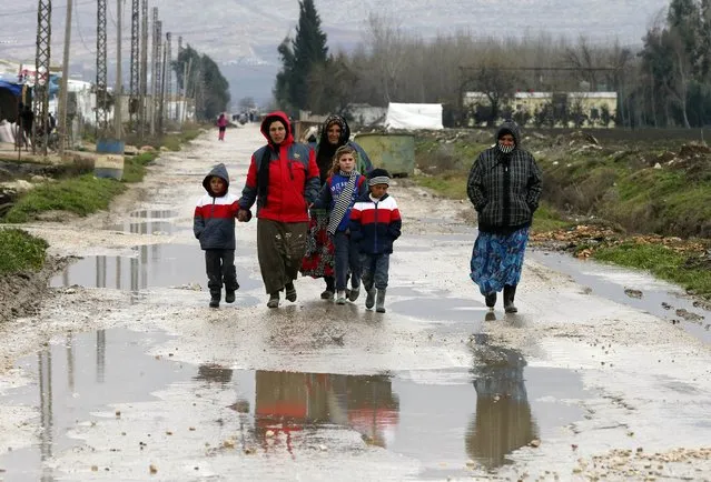Syrian refugees walk along a makeshift settlement in Bar Elias in the Bekaa valley January 5, 2015. (Photo by Mohamed Azakir/Reuters)