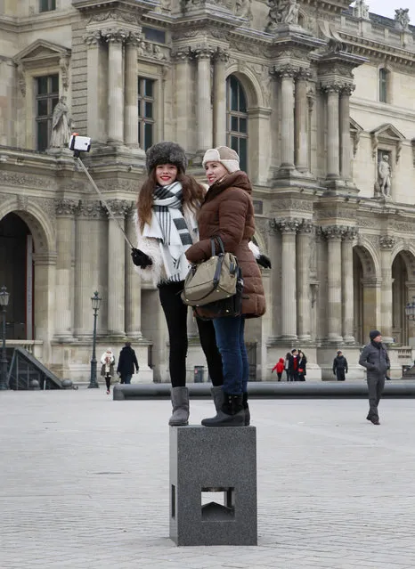 Tourists use a selfie stick  outside the Louvre museum in Paris, Tuesday, January 6, 2015. (Photo by Remy de la Mauviniere/AP Photo)