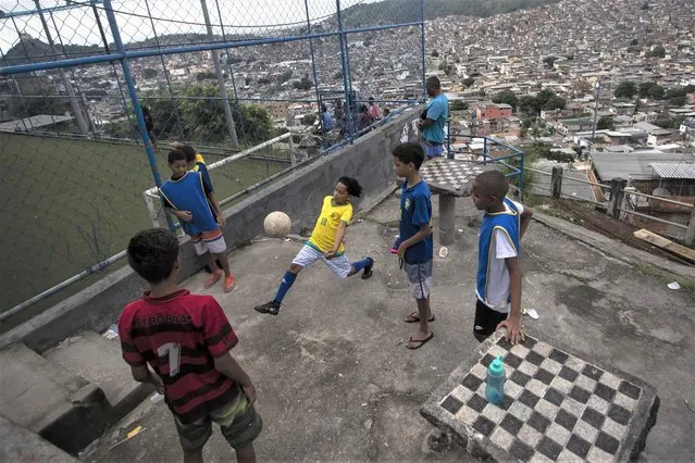 Boys play soccer in the Complexo da Penha favela, in Rio de Janeiro, Brazil, Saturday, April 29, 2023. (Photo by Bruna Prado/AP Photo)
