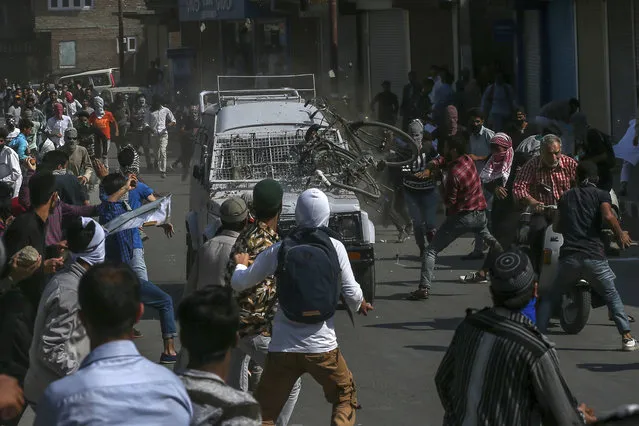 Kashmiri Protesters throw rocks, bricks and a cycle on an Indian paramilitary vehicle in Srinagar, Indian controlled Kashmir, Friday, June 1, 2018. Three people were injured, one of them seriously, after they were hit and run over by the vehicle. (Photo by Dar Yasin/AP Photo)