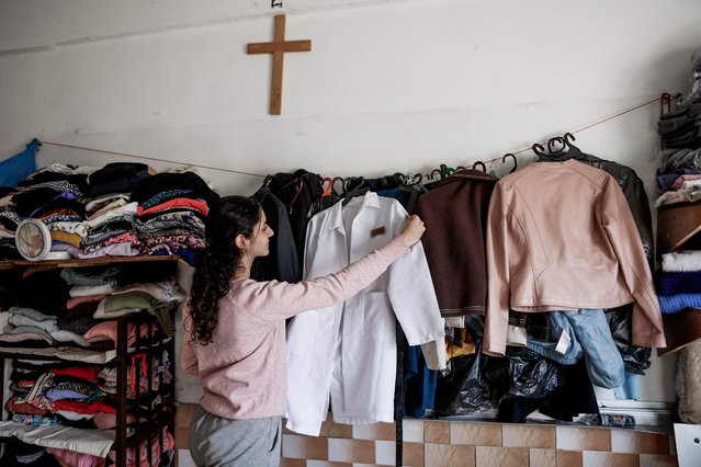 A displaced Palestinian girl adjusts clothing in a shelter inside the Holy Family Catholic Church compound in Gaza City, on December 3, 2025. Israel said on December 3, it would open the Rafah crossing from Gaza to Egypt to allow residents to exit the Palestinian territory “in the coming days”, but Egypt denied such a deal with Israel. (Photo by Omar Al-Qattaa/AFP Photo)