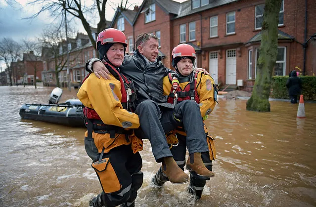 Rescue teams carry people to safety through the flood water as they continue to to evacuate homes after Storm Desmond caused flooding on December 7, 2015 in Carlisle, England. Storm Desmond has brought severe disruption to areas of northern England with dozens of flood warnings remaining in place throughout the country. (Photo by Jeff J. Mitchell/Getty Images)