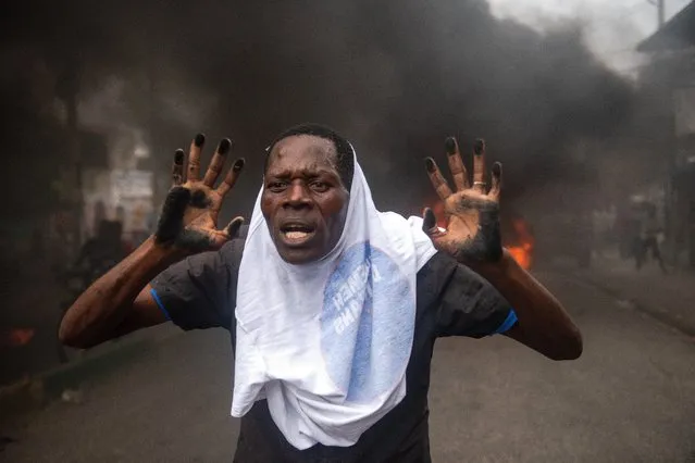 A person demonstrates to demand the resignation of President Moise, who is accused by the opposition of corruption, in the streets of Port-au-Prince, Haiti, 18 November 2020. At least one person has been killed and several injured during two demonstrations against the country's president Jovenel Moise and drafting of a new Constitution, on 19 November 2020. (Photo by Jean Marc Herve Abelard/EPA/EFE)