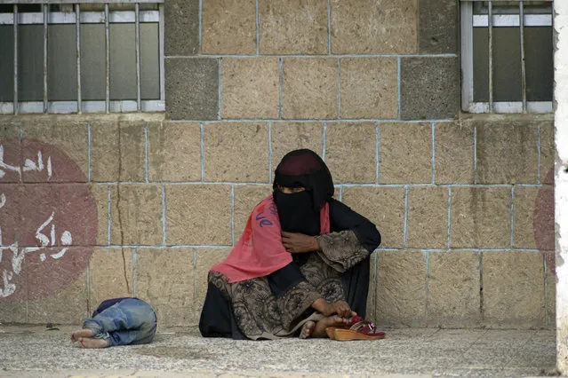 A displaced Yemeni woman and her child, who fled their home by the fighting the port city of Hodeida, sit in a school allocated for IDPs in Sanaa, Yemen, Saturday, Jun. 23, 2018. Last week, the Saudi-led coalition backing Yemen's internationally recognized government launched an offensive to retake rebel-held Hodeida. Fighting has been raging especially at and around the city's airport, threatening to worsen Yemen's humanitarian situation. (Photo by Hani Mohammed/AP Photo)