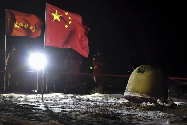 In this photo released by Xinhua News Agency, recovery crew members film the capsule of the Chang'e 5 probe after its successful landed in Siziwang district, north China's Inner Mongolia Autonomous Region on Thursday, December 17, 2020. A Chinese lunar capsule returned to Earth on Thursday with the first fresh samples of rock and debris from the moon in more than 40 years. (Photo by Ren Junchuan/Xinhua via AP Photo)