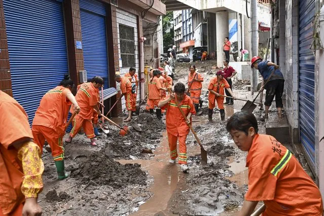 In this photo released by China's Xinhua News Agency, workers clean up silt and mud along a street in the Wanzhou district of Chongqing, China, Tuesday, July 4, 2023. More than a dozen people have been killed by floods in southwestern China as seasonal torrents hit mountain areas, authorities said Wednesday. (Photo by Ran Mengjun/Xinhua via AP Photo)