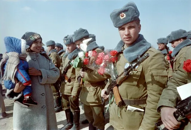 Red Army soldiers are welcomed with flowers in Termez, Uzbekistan, after crossing the Amu Darya river at the Soviet- Afghan border on February 15, 1989 during Soviet Army withdrawal from Afghanistan. The Soviet Union invaded Afghanistan in December 1979 to shore up the pro- Soviet regime in Kabul and maintained more than 100,000 troops in the country until completing their phased withdrawal in 1989. (Photo by Vitaly Armand/AFP Photo)
