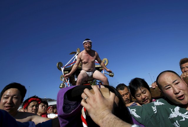 Man wearing the traditional “fundoshi” or loincloth rides on a “mikoshi” or portable shrine as local people carry it into the sea during a festival to wish for calm waters in the ocean and good fortune in the new year in Oiso, Kanagawa prefecture, west of Tokyo, Japan, January 1, 2016. (Photo by Yuya Shino/Reuters)