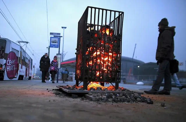 People warm themselves by a brazier on a tram stop in Katowice, Poland January 4, 2016 as the temperature dropped to below minus 15 degrees Celsius (5 degrees Fahrenheit) in some parts of Poland. (Photo by Dawid Chalimoniuk/Reuters/Agencja Gazeta)