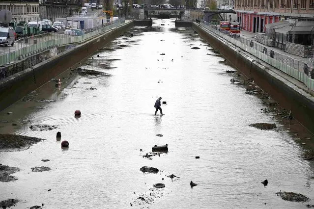 A worker wades in the water during the draining of the Canal Saint-Martin in Paris, France, January 5, 2016. (Photo by Charles Platiau/Reuters)