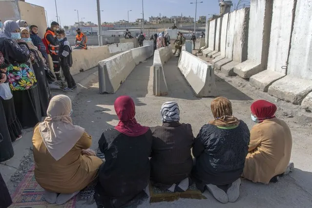 Palestinian women prepare to pray at the Qalandia checkpoint, to protest not allowing them to cross from the West Bank city of Ramallah toward Jerusalem, to attend the first Friday prayers in al-Aqsa mosque, during the Muslim holy month of Ramadan, Friday, April 16, 2021. A limited number of Palestinian residents who carry both a travel permit and a vaccination document, are allowed to cross into Israel to attend the prayers at al-Aqsa mosque, due to the coronavirus pandemic. (Photo by Nasser Nasser/AP Photo)
