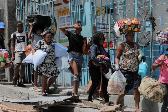 People carry their belongings as they flee their neighbourhood Carrefour Feuilles after gangs took over, in Port-au-Prince, Haiti on August 15, 2023. (Photo by Ralph Tedy Erol/Reuters)
