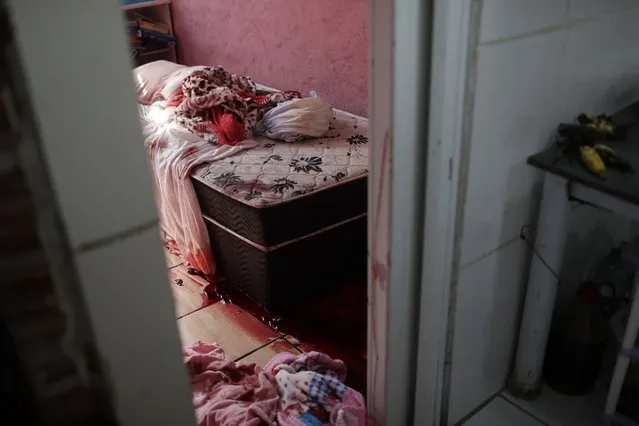 Blood covers the floor and a bed inside a home during a police operation targeting drug traffickers in the Jacarezinho favela of Rio de Janeiro, Brazil, Thursday, May 6, 2021. (Photo by Silvia Izquierdo/AP Photo)