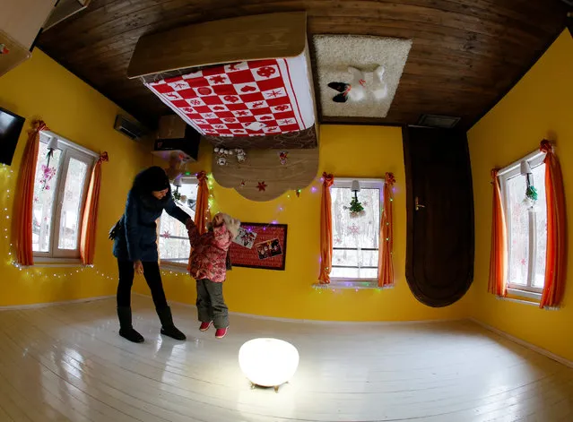 People visit an upside down house, constructed as an attraction for local residents and tourists and located at the Royev Ruchey Park of Flora and Fauna in the suburbs of Krasnoyarsk, Russia, December 7, 2016. (Photo by Ilya Naymushin/Reuters)