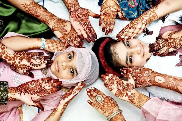 Girls show their hands decorated with henna designs on the occasion of Eid Al Fitr in the old city of Hyderabad, India, on May 14, 2021. (Photo by Xinhua News Agency/China Stringer Network)