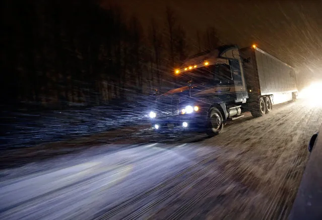 A tractor trailer rig drives during a snowstorm along the Atlantic City Expressway,  Friday, January 22, 2016, near Atlantic City. Most of the state was facing a blizzard warning from Friday evening until Sunday that called for up to 24 inches of snow, with the deepest accumulations in the central part of the state. (Photo by Mel Evans/AP Photo)