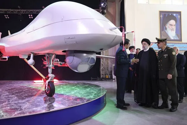 In this photo released by the Iranian Presidency Office, President Ebrahim Raisi, second right, listens to Chief of Aviation Industries of Armed Forces Gen. Afshin Khajehfard, as Defense Minister Gen. Mohammad Reza Gharaei Ashtiani, right, listens, during a ceremony unveiling a drone called the Mohajer-10, Tuesday, August 22, 2023. Iran's Defense Ministry unveiled a drone Tuesday resembling America's armed MQ-9 Reaper, claiming that the aircraft capable of staying airborne for 24 hours and having the range to reach its archenemy Israel. (Photo by Iranian Presidency Office via AP Photo)