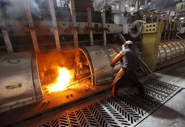 A worker operates an electrolysis furnace, which produces aluminium from raw materials, at the Rusal Krasnoyarsk aluminium smelter in the Siberian city of Krasnoyarsk, in this May 18, 2011 file photo. (Photo by Ilya Naymushin/Reuters)