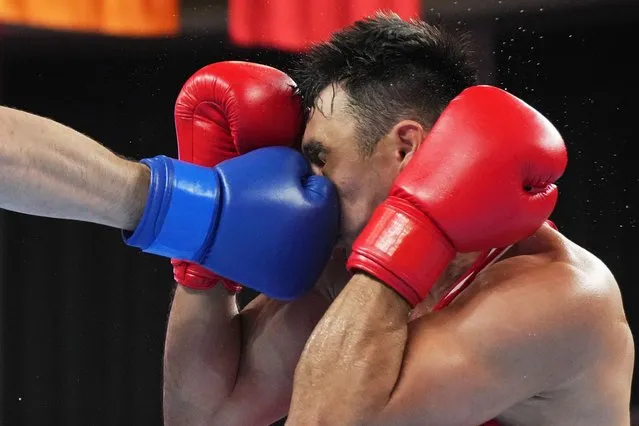 Kazakhstan's Kamshybek Kunkabayev receives a punch from Uzbekistan's Bakhodir Jalolov during the men's +92Kg boxing final at the 19th Asian Games in Hangzhou, China, Thursday, October 5, 2023. (Photo by Vincent Thian/AP Photo)