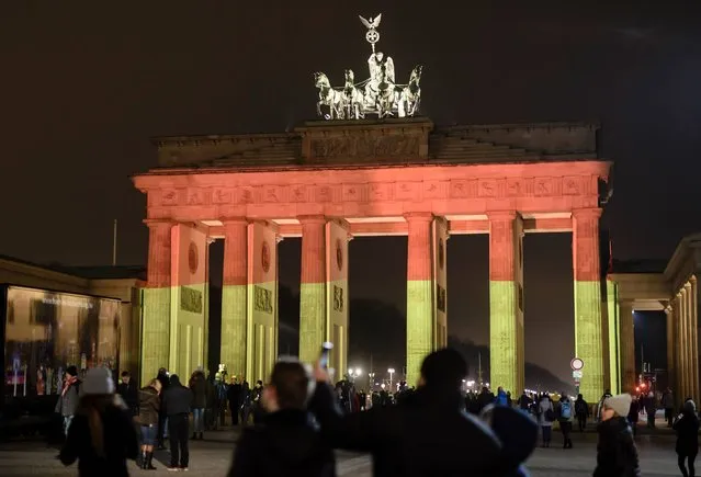 The Brandenburg Gate is seen in the colors of the German flag in Berlin on December 20, 2016 one day after a truck crashed into a Christmas market. German police said they were treating as “a probable terrorist attack” the killing of 12 people when the speeding lorry cut a bloody swath through the packed Berlin Christmas market. (Photo by Clemens Bilan/AFP Photo)