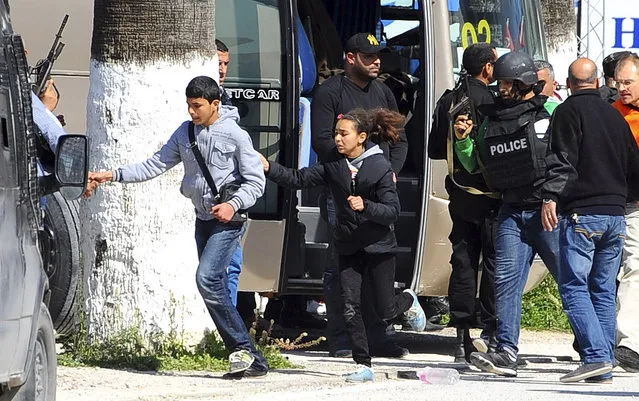 Tourists and visitors from the Bardo museum are evacuated in Tunis, Wednesday, March 18, 2015 in Tunis, Tunisia. Gunmen opened fire at a leading museum in Tunisia's capital, killing 19 people  including 17 tourists, the Tunisian Prime Minister said. A later raid by security forces left two gunmen and one security officer dead but ended the standoff, Tunisian authorities said. (Photo by Hassene Dridi/AP Photo)